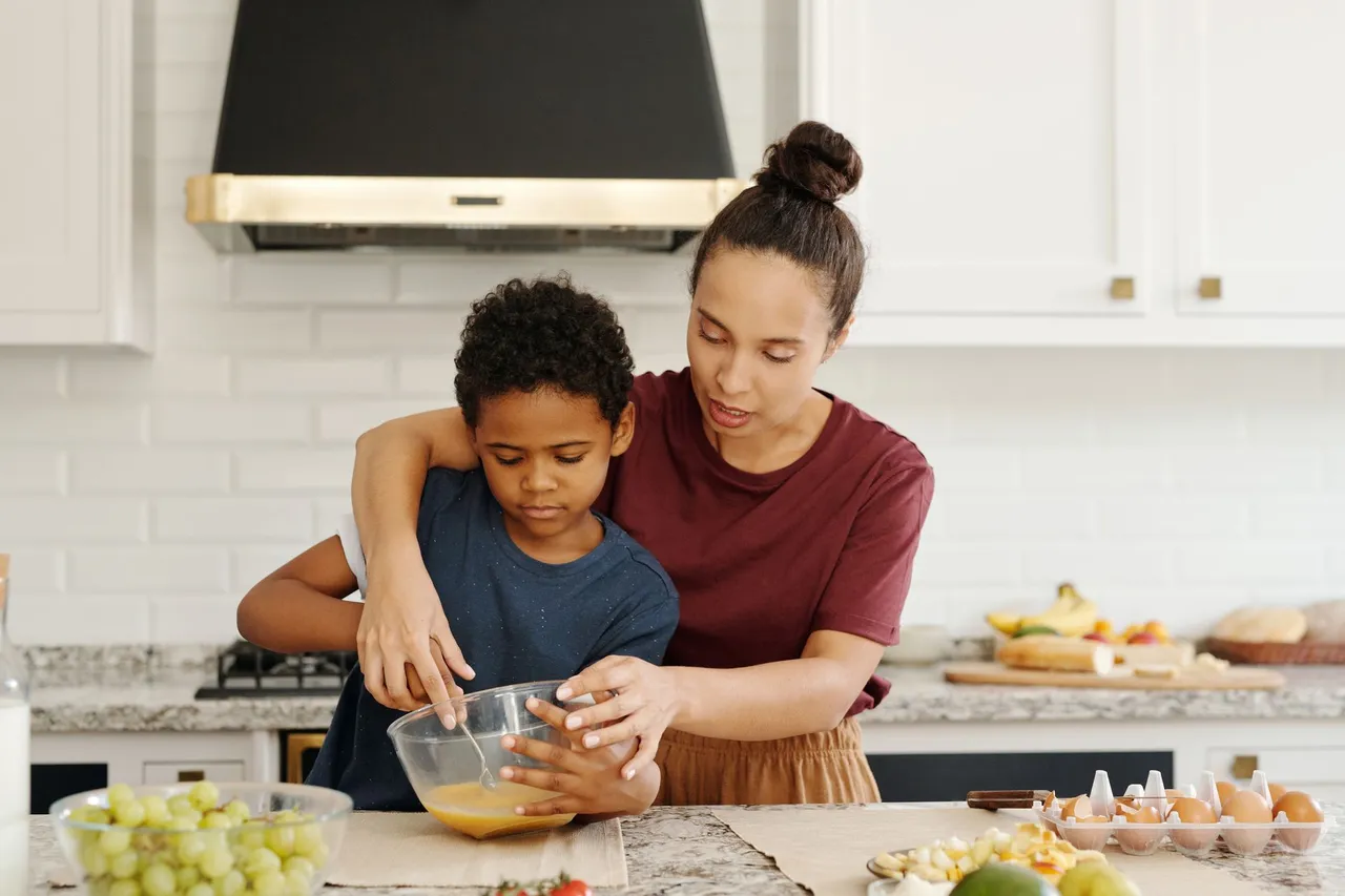 Une mère et son fils préparent un gâteau dans la cuisine