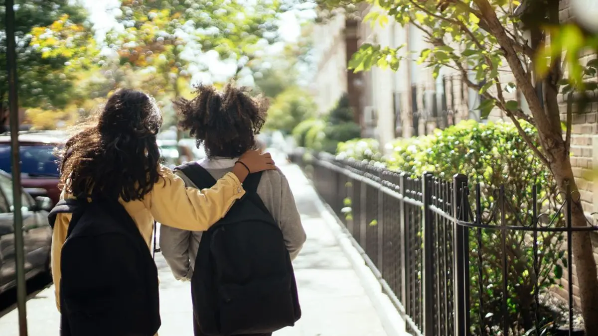 Deux adolescentes avec leur sac à dos sur le chemin du lycée