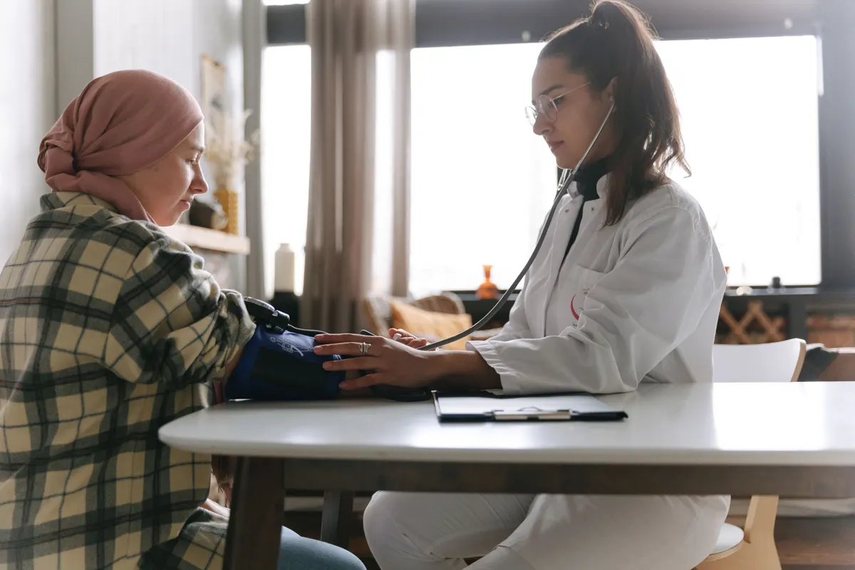 Sage-femme prenant la tension d'une patiente lors d'une consultation