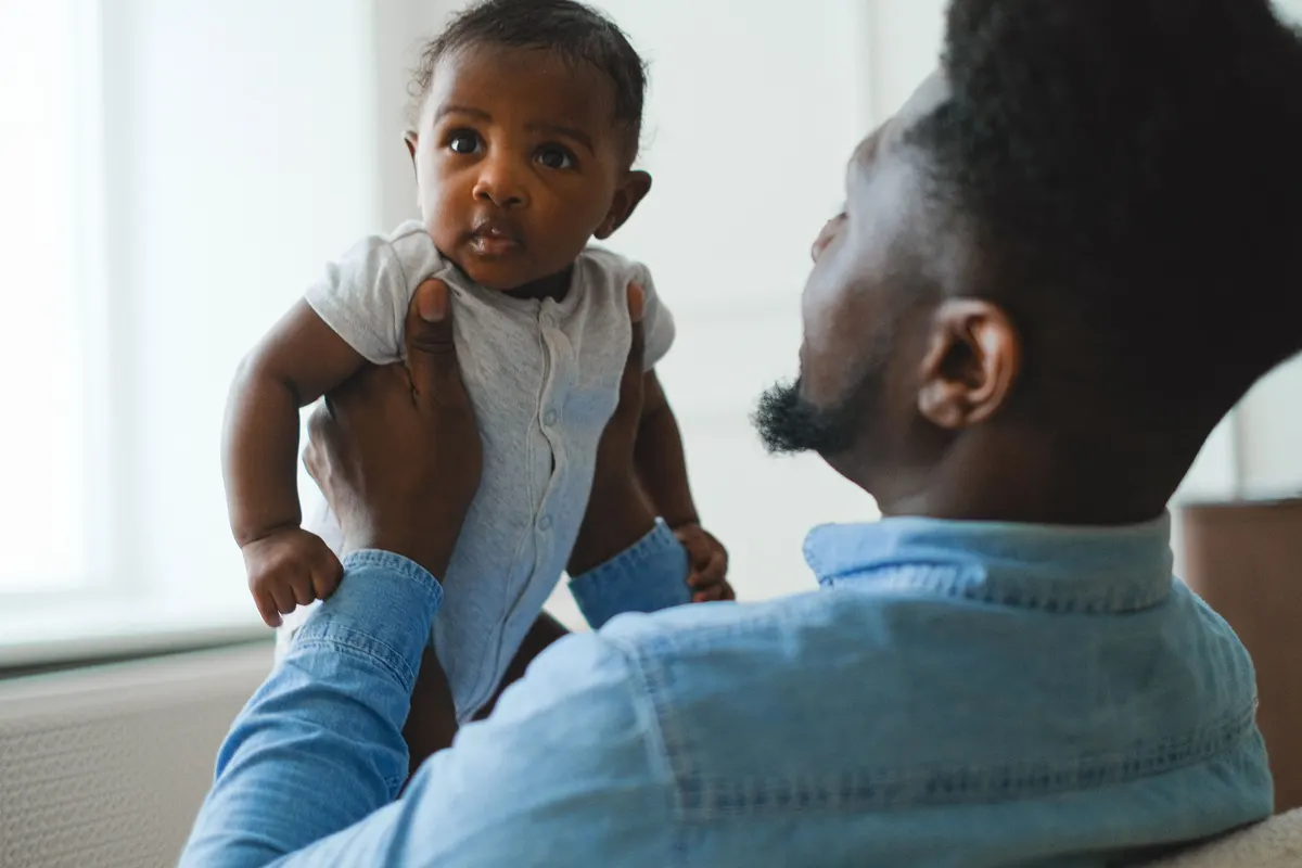 Père tenant son nouveau-né dans les bras à la maison