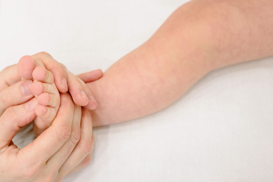 Parent examinant avec attention la peau du bras d'un enfant pour repérer d'éventuels boutons de varicelle