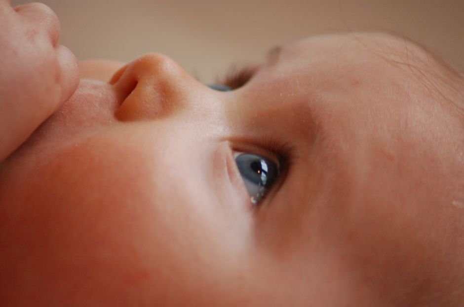 Gros plan sur le visage d'un bébé, cils et œil au premier plan, illustrant une conjonctivite du nourrisson