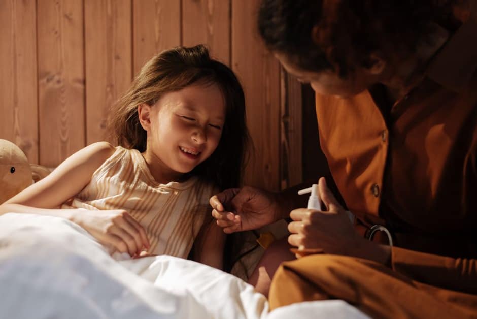 Parent au chevet d'une petite fille fatiguée, allongée avec son doudou