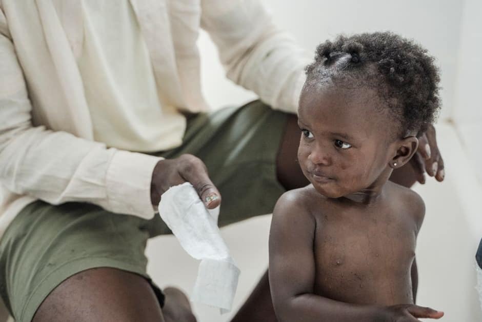 Parent essuyant le nez d'un tout-petit près du point d'eau, après un lavage au sérum physiologique