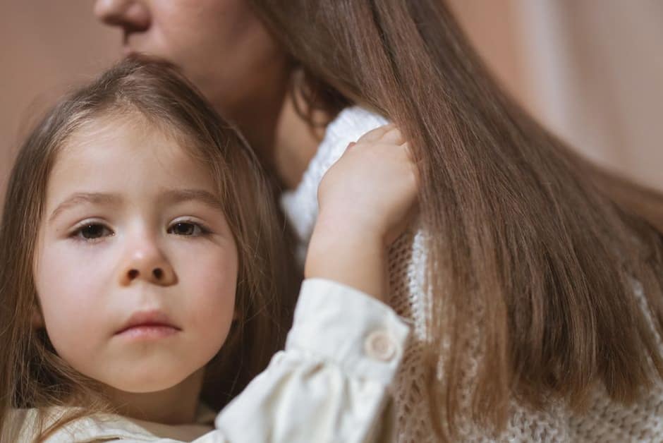 Petite fille blottie contre sa mère aux longs cheveux : les lentes se cherchent mèche par mèche