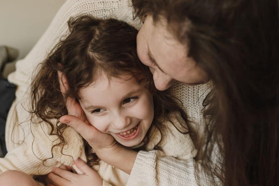 Maman posant tendrement la main sur la joue de sa fille, la zone sensible des oreillons