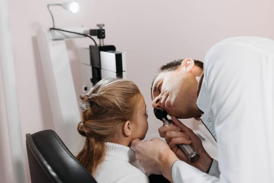 Médecin examinant une jeune enfant en cabinet : la rougeole se confirme toujours en consultation