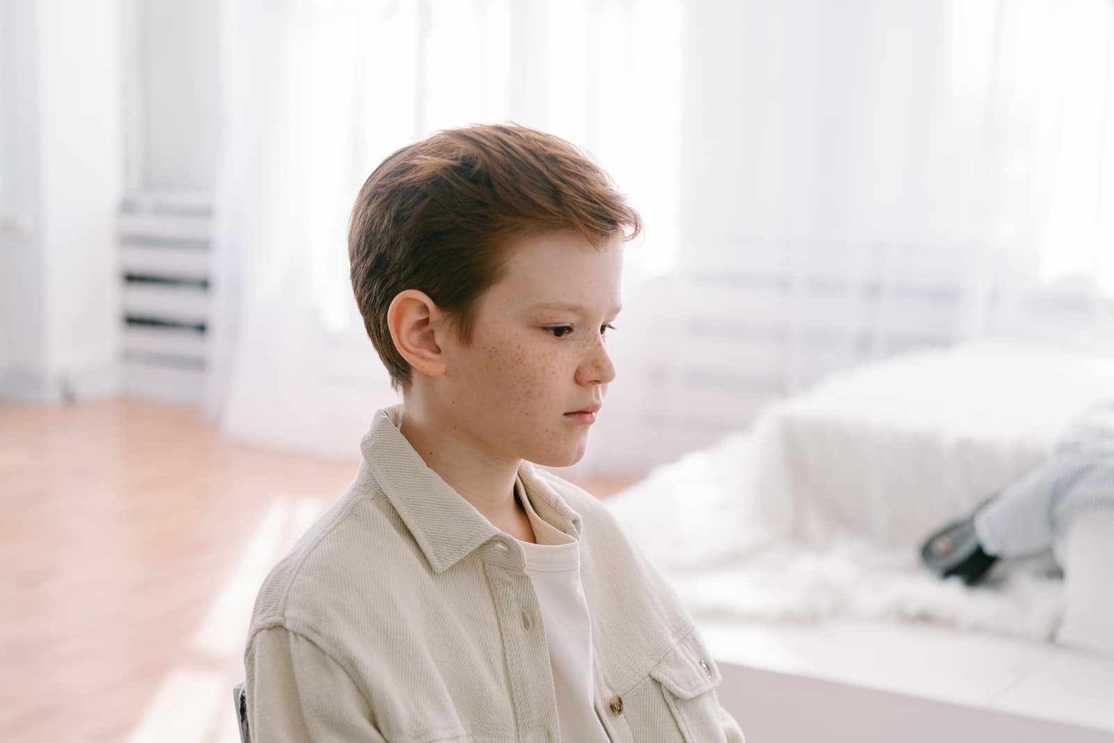 Jeune garçon avec des petits boutons sur le visage, au calme dans sa chambre