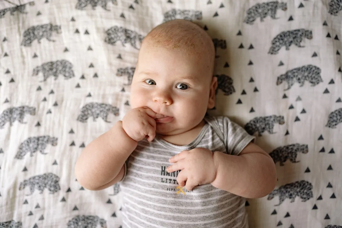 Bébé de 3 mois allongé sur une couverture, les yeux grands ouverts