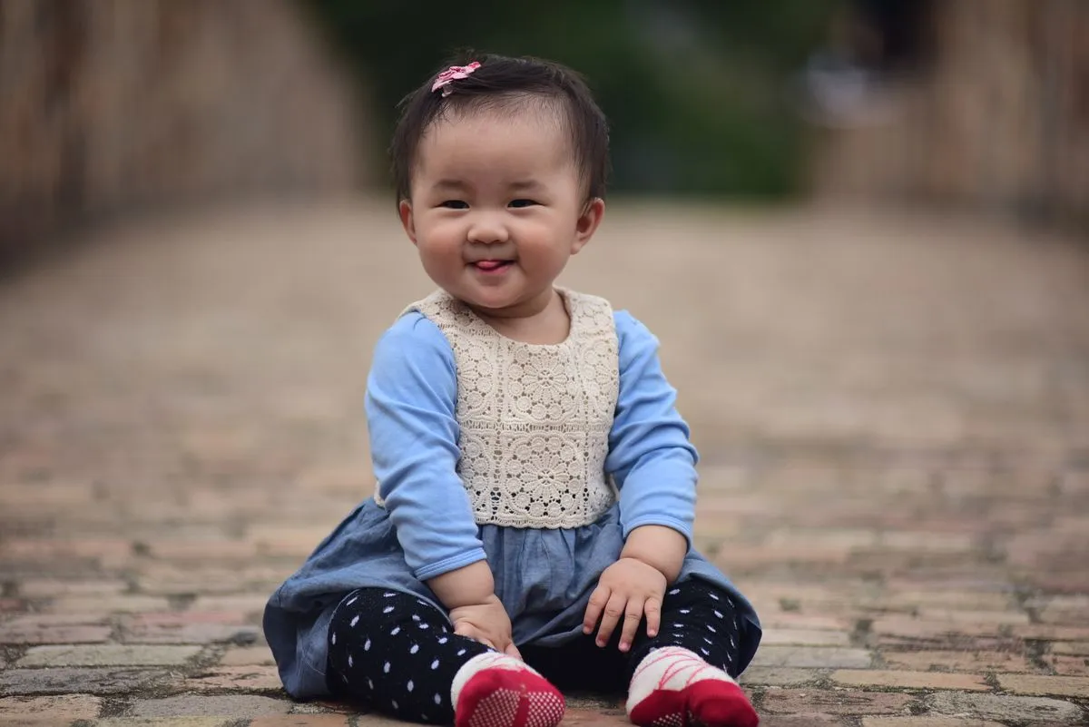 Bébé de 6 mois qui tient assise toute seule et sourit